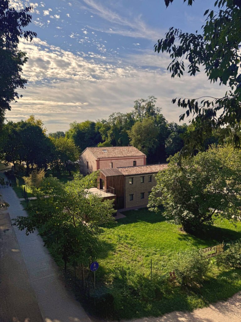 Edificio moderno immerso nel verde con cielo nuvoloso