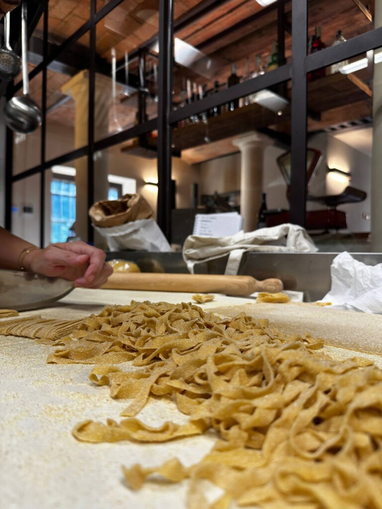 Tagliatelle fresche fatte a mano su un tavolo infarinato.